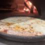 Tegia di pizza margherita in forno a legna