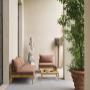 Outdoor entryway to Aelia Spa with terracotta planters, sculptural accents, and cushioned lounge chairs creating a tranquil Mediterranean-inspired atmosphere.