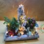 composizione piante e fiori decorata con neve, luci e natività